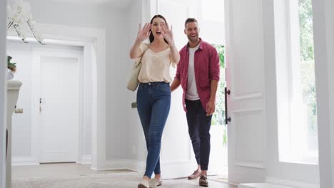 Un-Emocionado-Hijo-Caucásico-En-Casa-Corriendo-Para-Saludar-A-Sus-Sonrientes-Padres-Que-Entran-Por-La-Puerta-Principal.