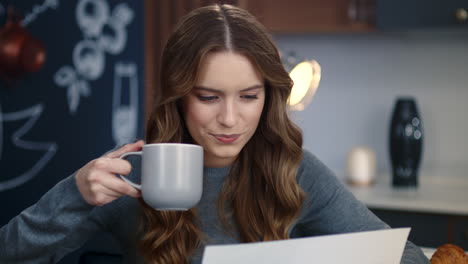 portrait of focused businesswoman reading financial documents at home office.