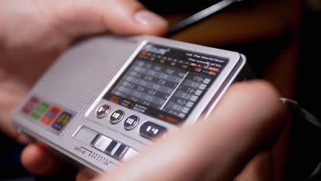 a male tunes a radio frequency on a small receiver with an antenna. 4k. close up