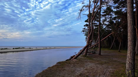 Ruhige-Schwenkaufnahme-Eines-Menschenleeren-Strandes-Und-Einer-Weichen-Böschung,-Die-Sich-Ins-Meer-Erstreckt-Und-Eine-Lagune-Bildet,-Kopierraum