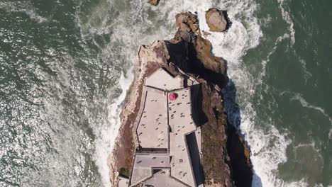 vista aérea de arriba hacia abajo sobre el faro de nazaré o nazare, portugal