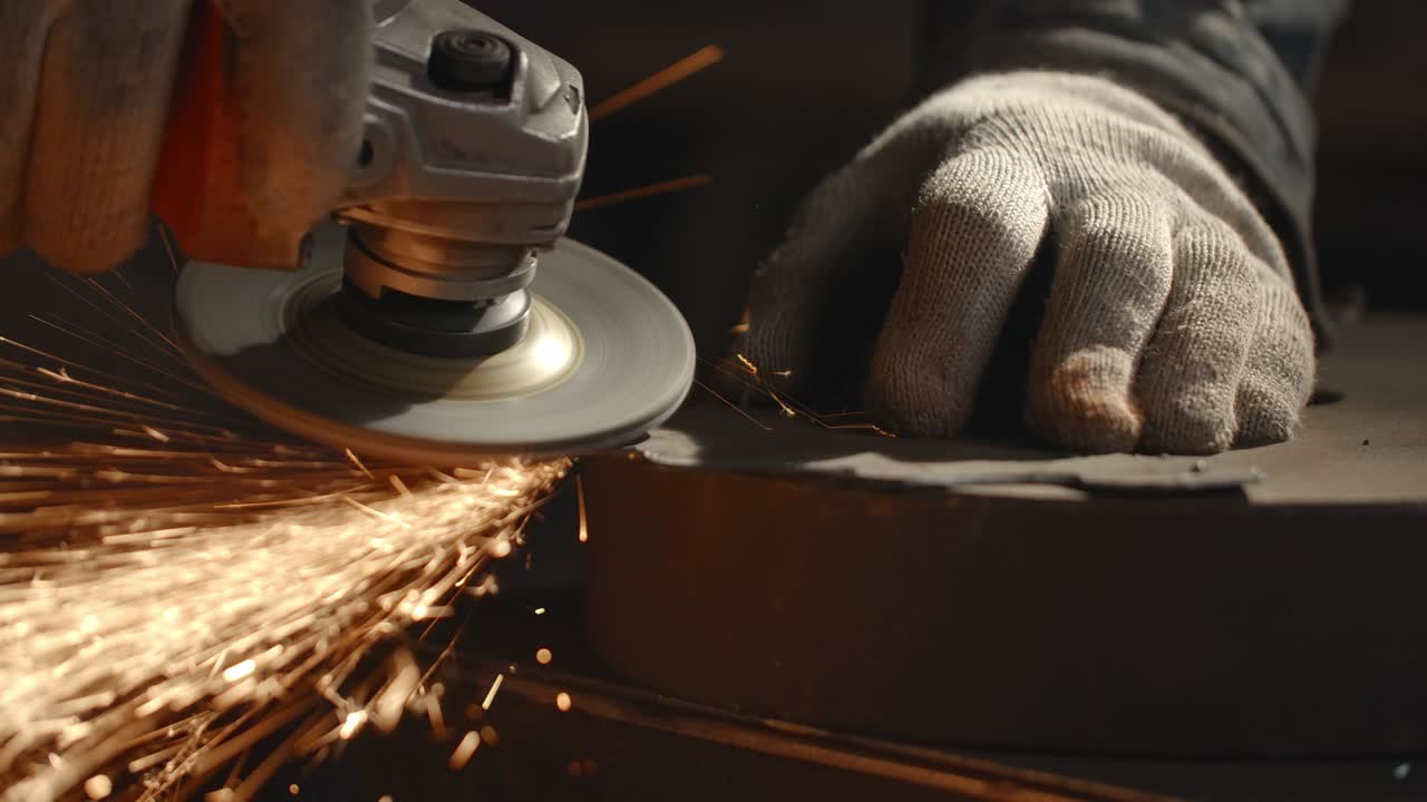 cerrajero limpia los bordes de un detalle metálico con un molinillo eléctrico con muchas chispas en cámara lenta, trabajo de metal en el taller, 4k 60p prores hq