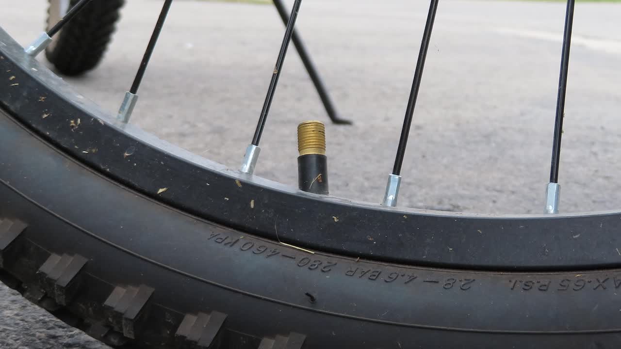 자전거 타이어에 공기를 공급하기 위해 검정색 플라스틱 밸브 캡을 풀고 캡을 제거하여 자전거 타이어 바퀴에 공기를 채웁니다. - 자전거 바퀴에서 뚜껑을 제거하여 자전거 타이어를 부풀립니다.