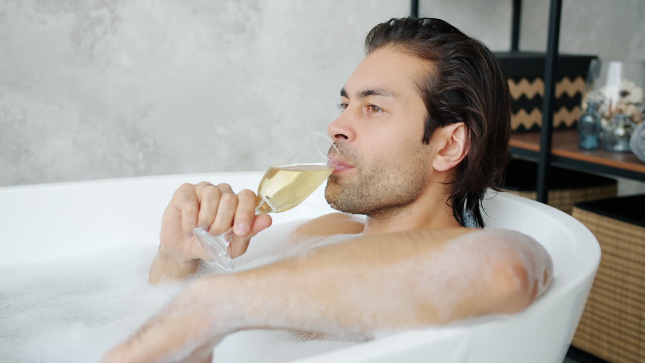 Man Relaxing in a Bubble Bath with Champagne