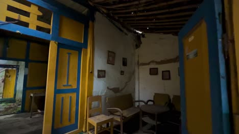 dark, empty, scary living room with family photos, broken furniture and damaged wall