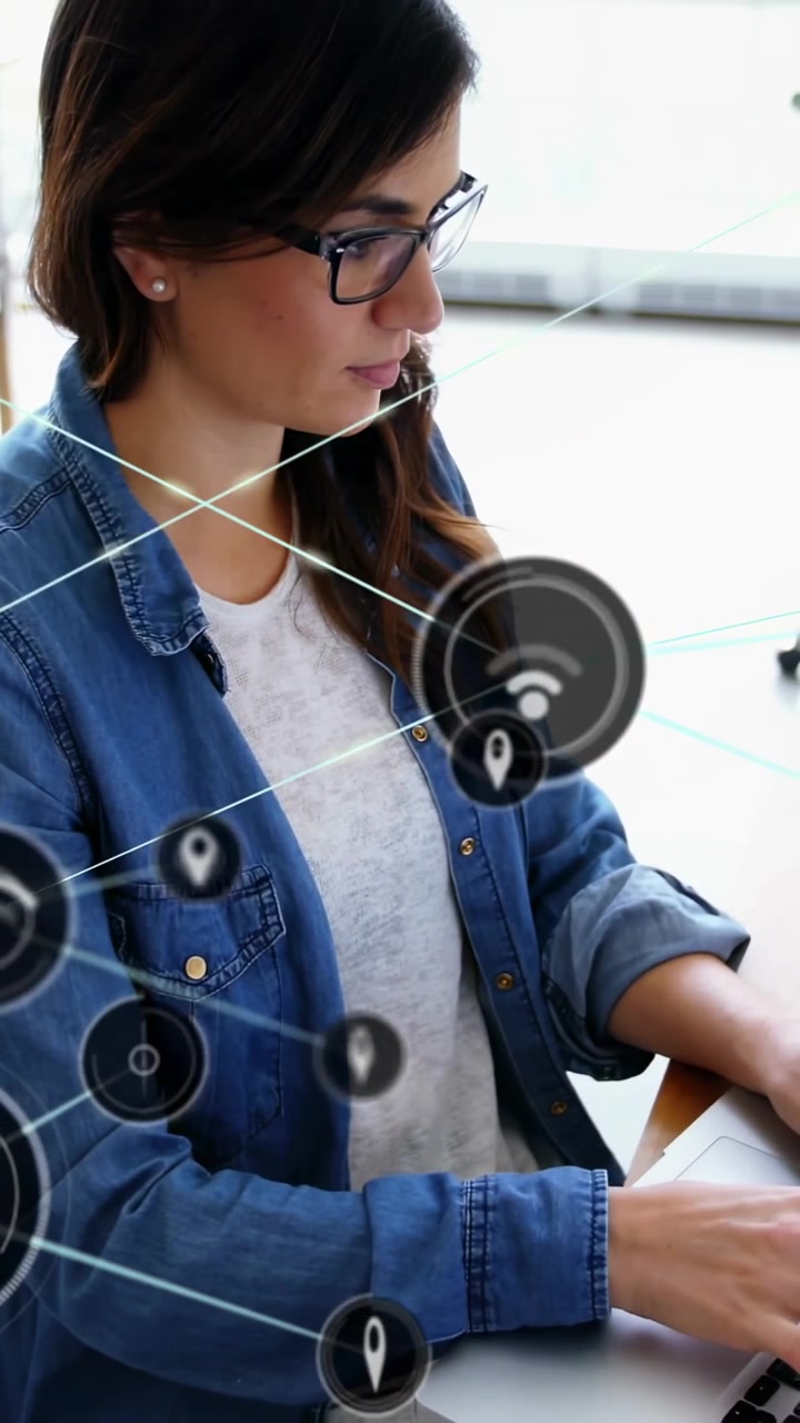 Video verticale: Donna che digita al laptop, con un cerchio HUD che appare, pin che si collegano e nodi mappati per la tecnologia.