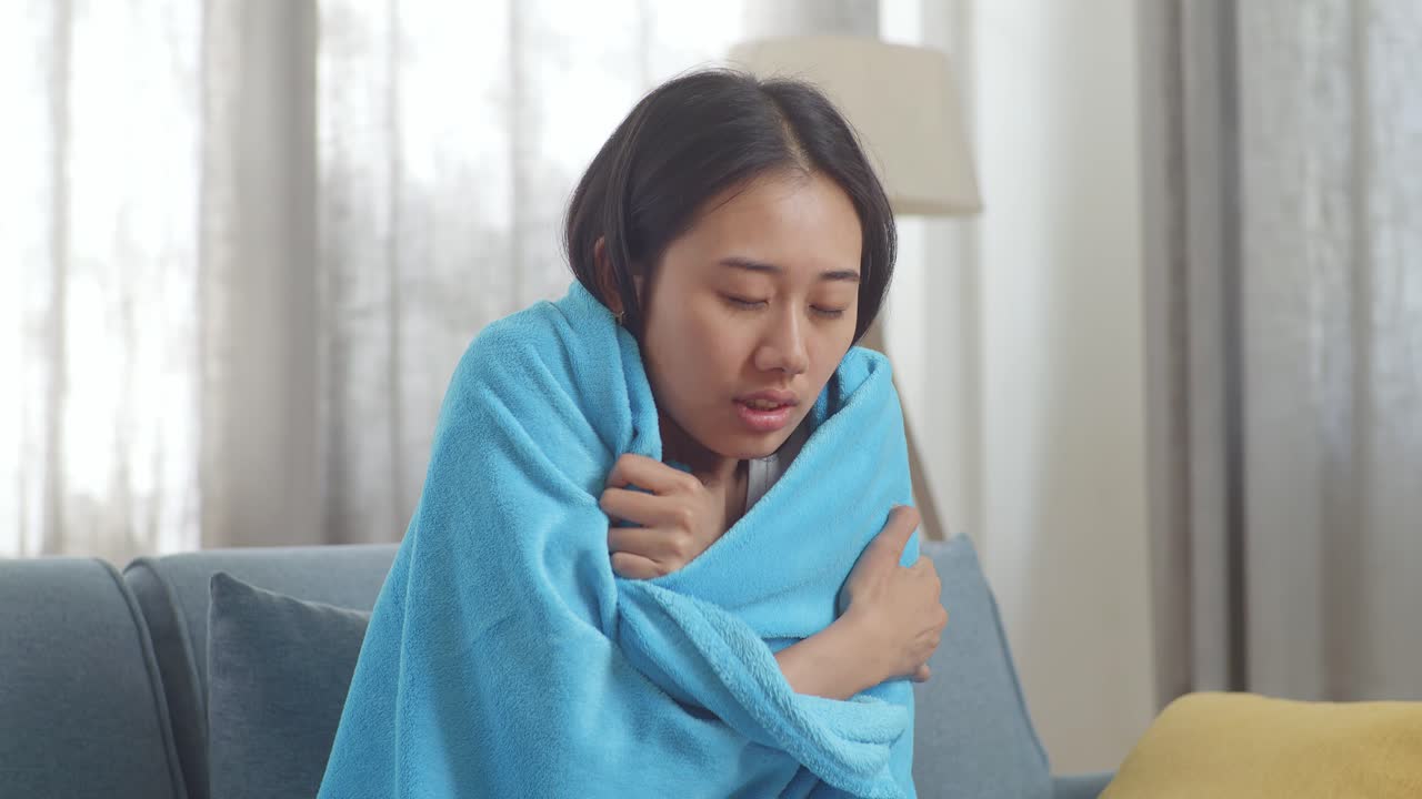 Woman wrapped in a blanket, appearing ill