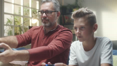 father and son playing video games at home