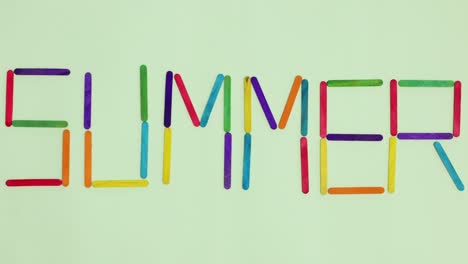 writing summer word with wooden colorful sticks. stop motion