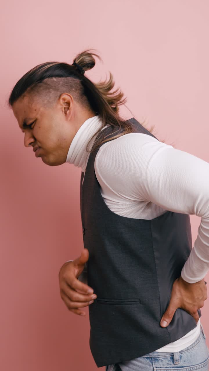 Young Man Grimacing in Pain from Stomach and Back Ache