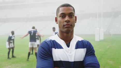 Male-rugby-player-standing-with-arms-crossed-in-stadium-4k