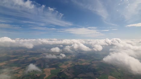 vuelo lento con un avión a través de las nubes y tierras agrícolas planas de alemania visible abajo