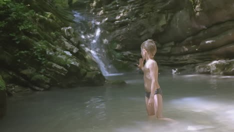 a boy exploring a waterfall creek