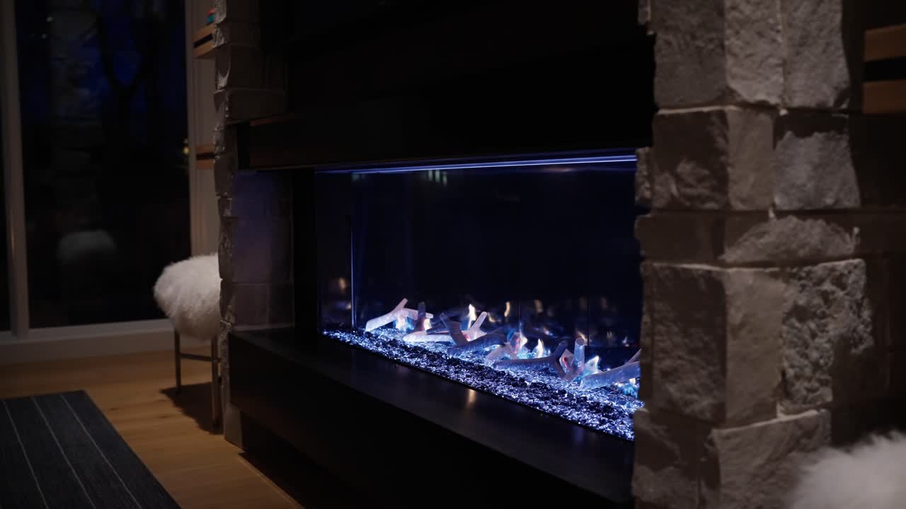 chimenea de gas incandescente con luces azules en el hogar moderno de lujo
