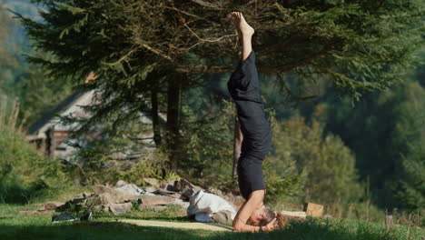 young woman standing on head at lawn