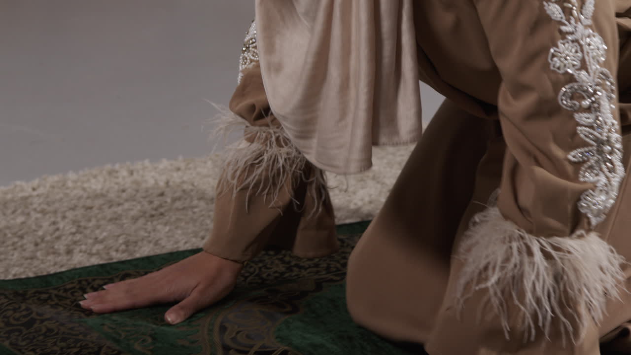 близкий взгляд на мусульманку в хиджабе дома, молящуюся на коленях на молитвенном коврике 1