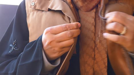 woman wearing a brown vest and hijab