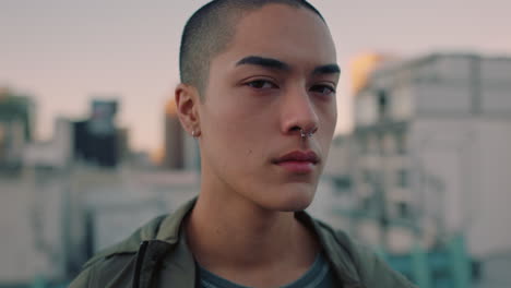 Retrato-Atractivo-Joven-De-Raza-Mixta-Con-El-Pelo-Afeitado-En-La-Azotea-Al-Atardecer-Usando-Piercings-Que-Parece-Confiado-En-El-Fondo-Urbano-De-La-Ciudad