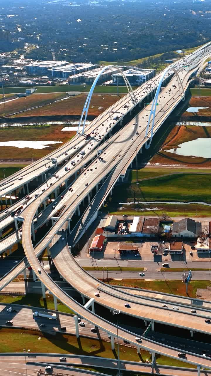 Mobil-mobil bergerak melintasi jembatan indah di Dallas, Texas. Pemandangan metropolis yang menakjubkan dari ketinggian.
