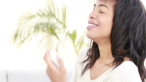 Smiling-woman-using-asthma-inhaler-at-home