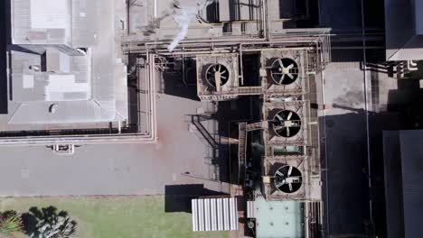 smoke and seam coming out of the roof of a cotton factory - straight down aerial view