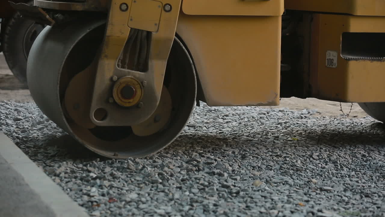 Road roller laying gravel during road construction