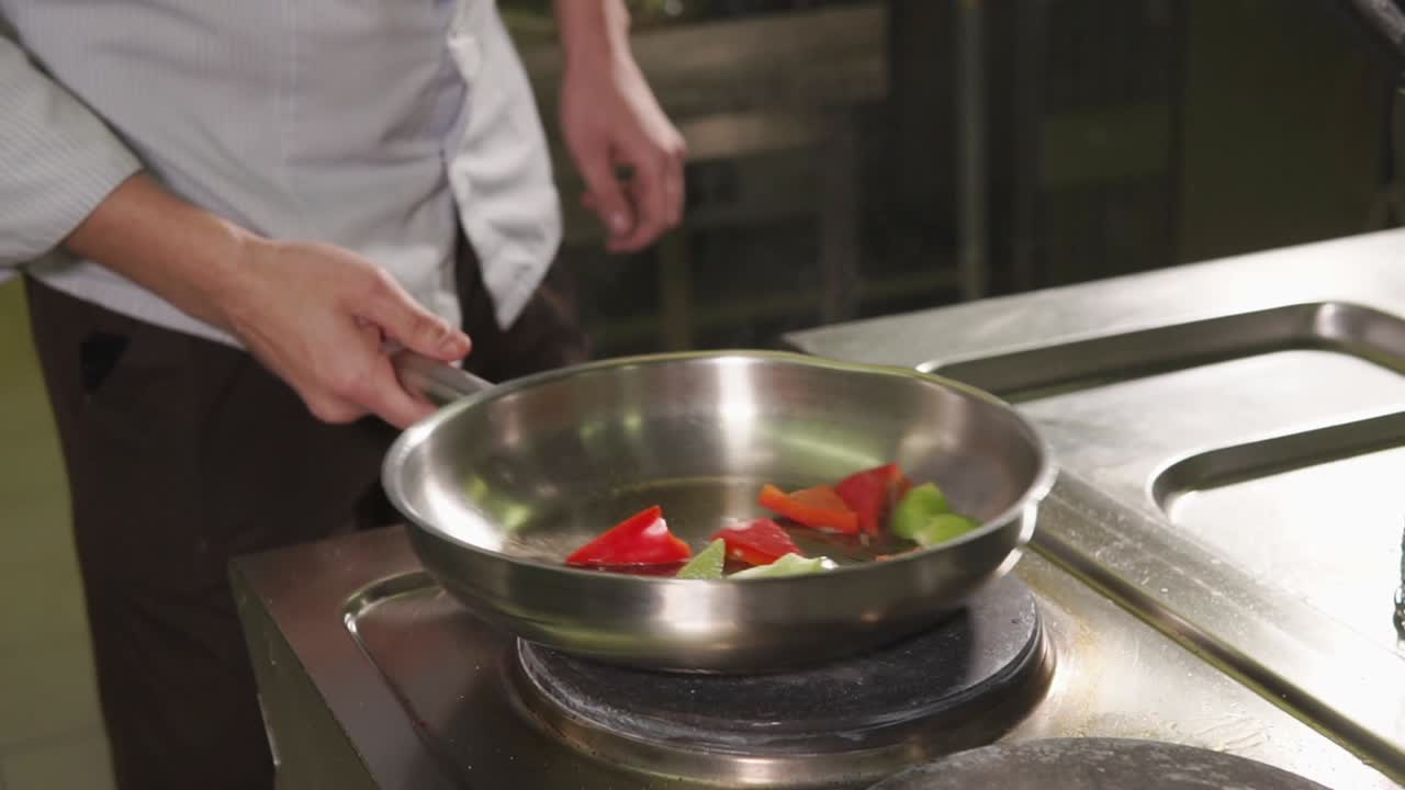 chef cocinando verduras en una sartén