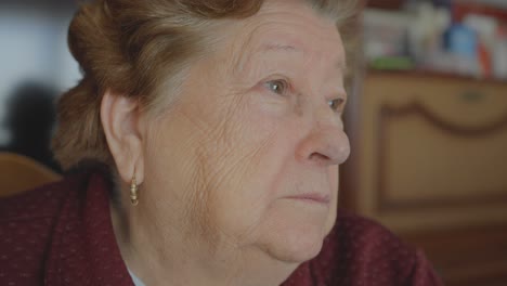 Close-up-of-playful-grandmother-winking-with-tongue-out-then-looking-away