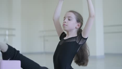 young ballerina practicing dance moves in studio