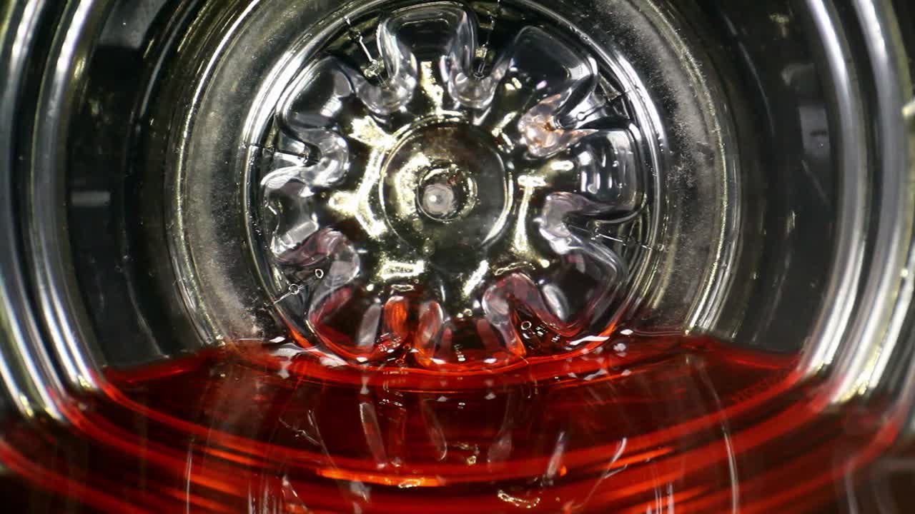 dentro del fondo de una bebida deportiva o de una botella de jugo, la botella se golpea - el líquido rojo se mueve ligeramente