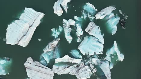 Aerial-shot-of-floating-glaciers-moving-on-water-in-Iceland-during-winter