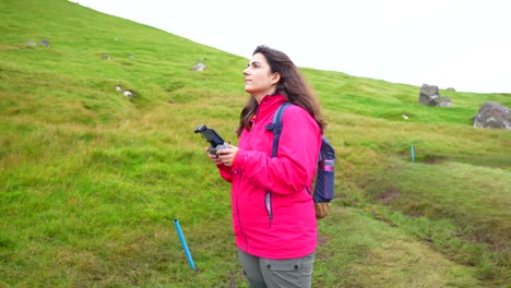female pilot plays outdoor with new drone, faroe islands