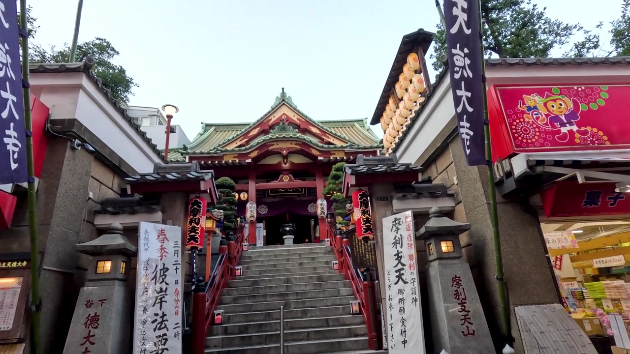 Lavvinklet nedadgående panorering, der afslører en historisk Shinto-helligdomsindgang med bannere i Tokyo, Japan.