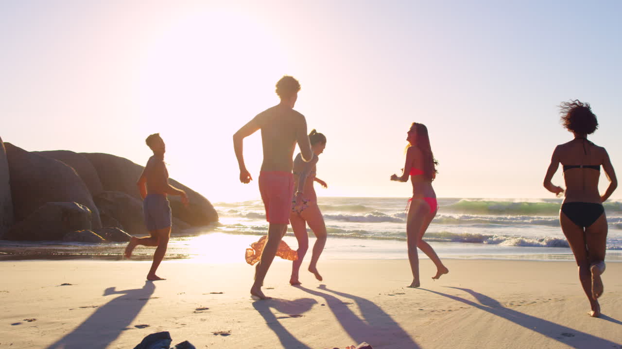 해가 지면 해변에서 달리는 친구들