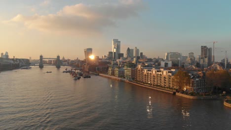 slider drone shot over london thames river towards city centre sunset