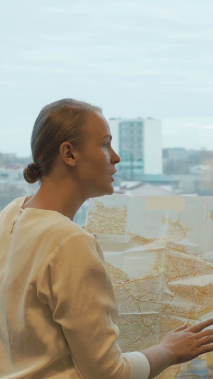 Donna che guarda una mappa vicino alla finestra