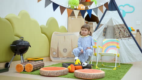 playful toddler pretends camping at playroom