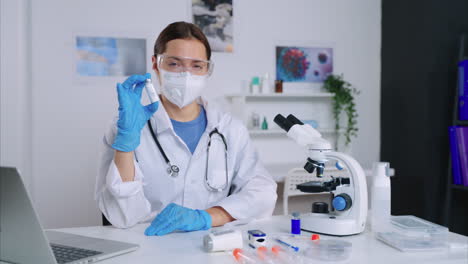 científica en bata de laboratorio con equipo de protección
