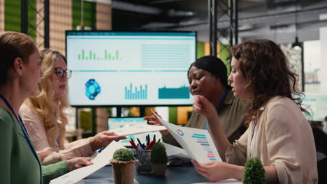 vertical video empowered group of women strategizing together with data reports