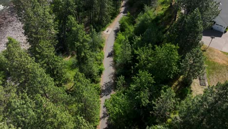 Toma-Aérea-De-Arriba-Hacia-Abajo-De-Ciclistas-Que-Recorren-El-Sendero-Del-Parque-Estatal-Del-Centenario-Del-Río-Spokane