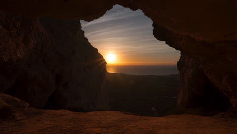 sunset over the ocean viewed from a cave