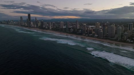 Costa-Dorada,-Paraíso-De-Los-Surfistas,-Queensland,-Australia,-Drone,-A-Medida-Que-Se-Acerca-La-Noche,-Un-Sobrevuelo-Mientras-Las-Olas-Rompen-En-Este-Hermoso-Lugar