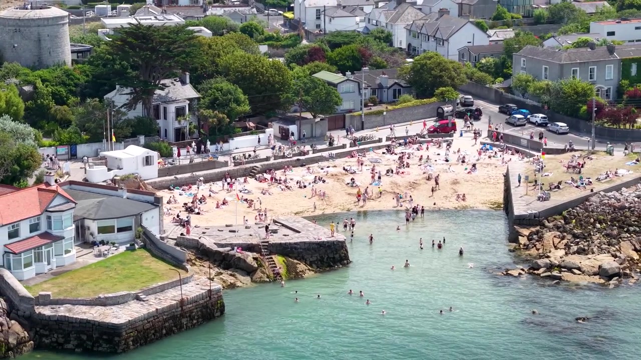 Splendida vista aerea ravvicinata della affollata spiaggia di Sandycove e del mare cristallino, Dublino, Irlanda