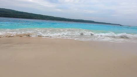 Aguas-Azules-Onduladas-En-Una-Playa-De-Arena-Blanca