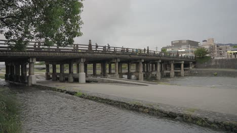 people walk across kamogawa bridge, slow motion