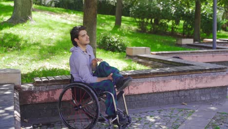 joven discapacitado sentado en silla de ruedas en cámara lenta.