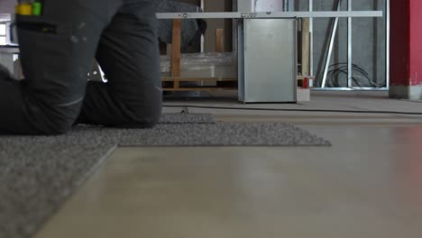 trabajador que instala el piso de alfombra en el sitio de construcción