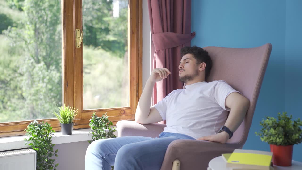 우울한 남자. 남자는 창문 밖을 바라보고 있다.