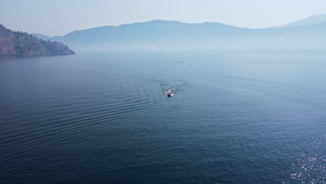 Two-speed-boats-driving-over-deep,-blue-Okanagan-Lake-on-a-hot-summer-day-in-Canada