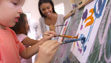 teacher at montessori school helping children in art class